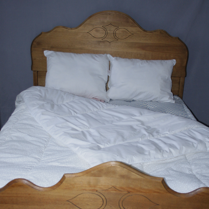 Couette en laine sur un lit avec oreillers.